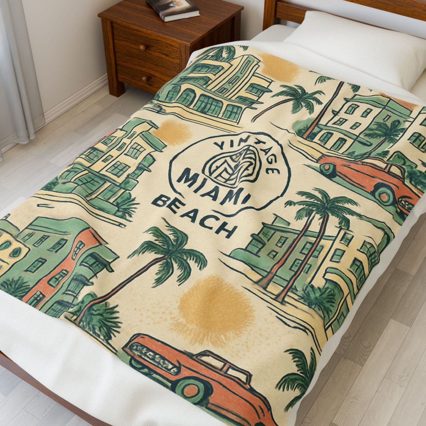 Miami Beach-themed blanket on a bed with a wooden nightstand.