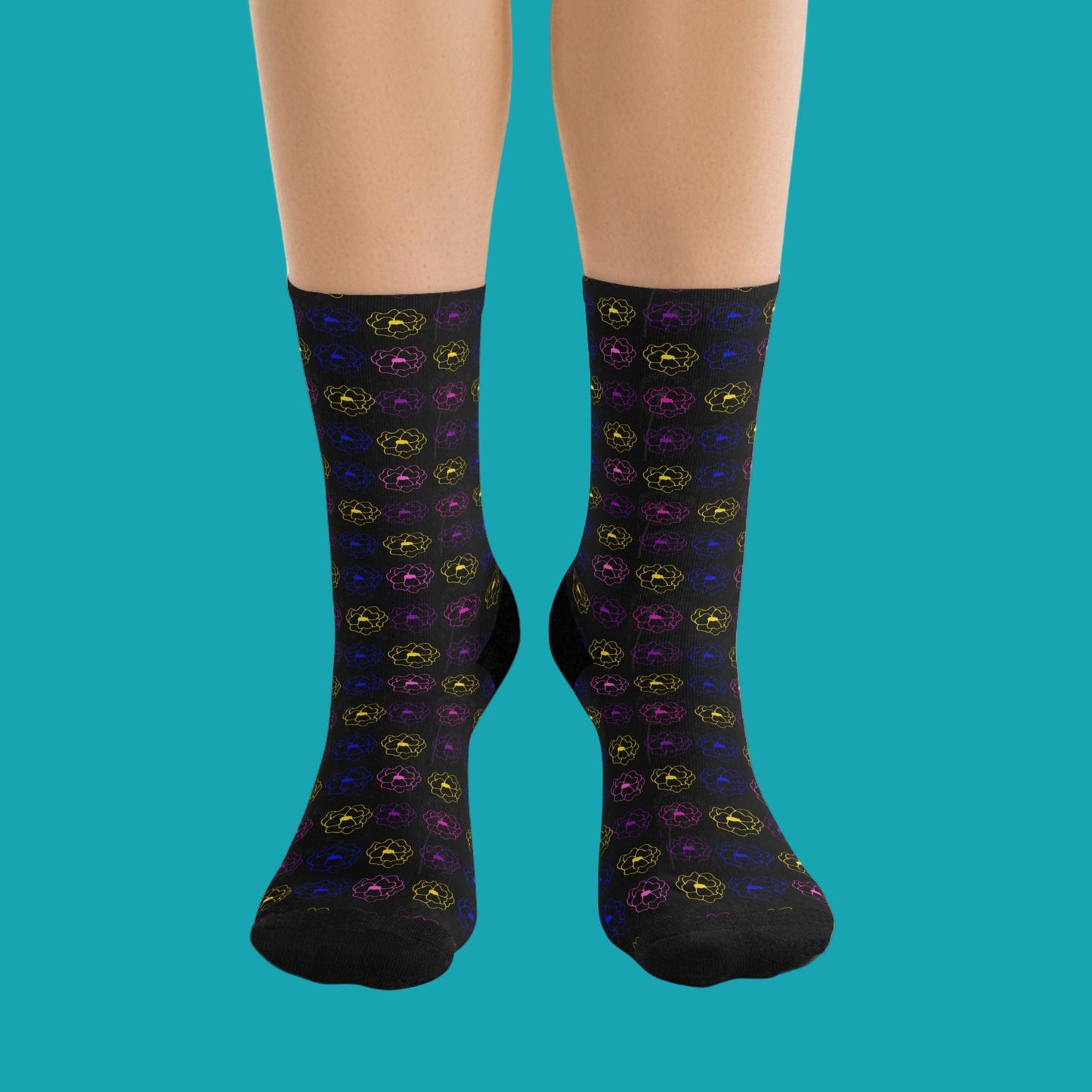 Black socks with colorful pattern worn by a person on a white background