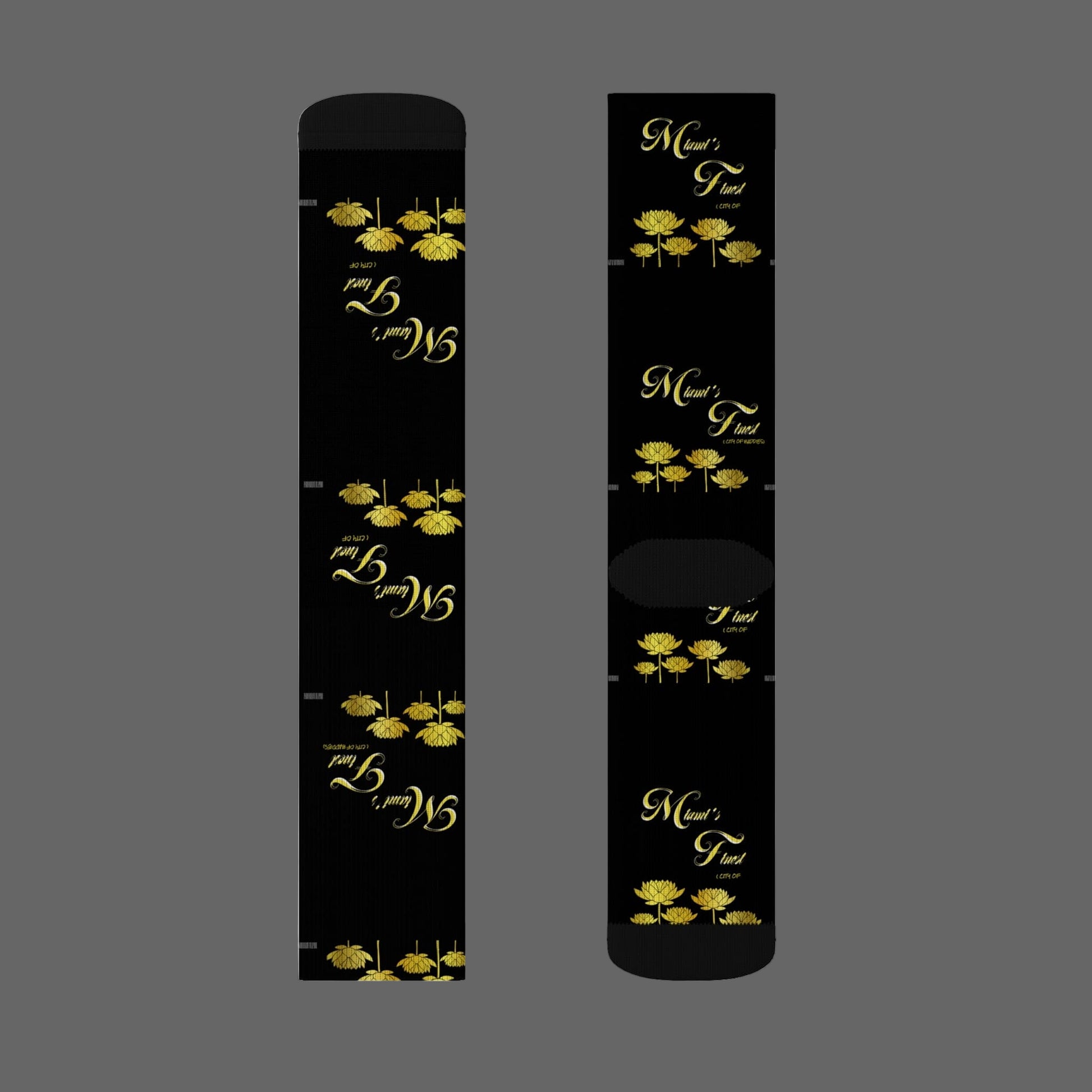 Two black cylindrical products with gold floral designs and text on a white background