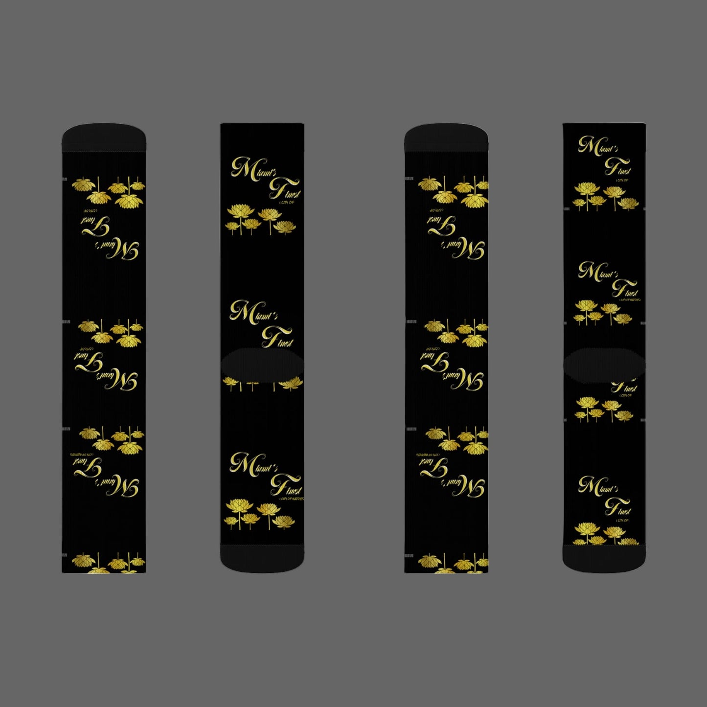 Four black cylindrical products with gold floral designs and text on a white background