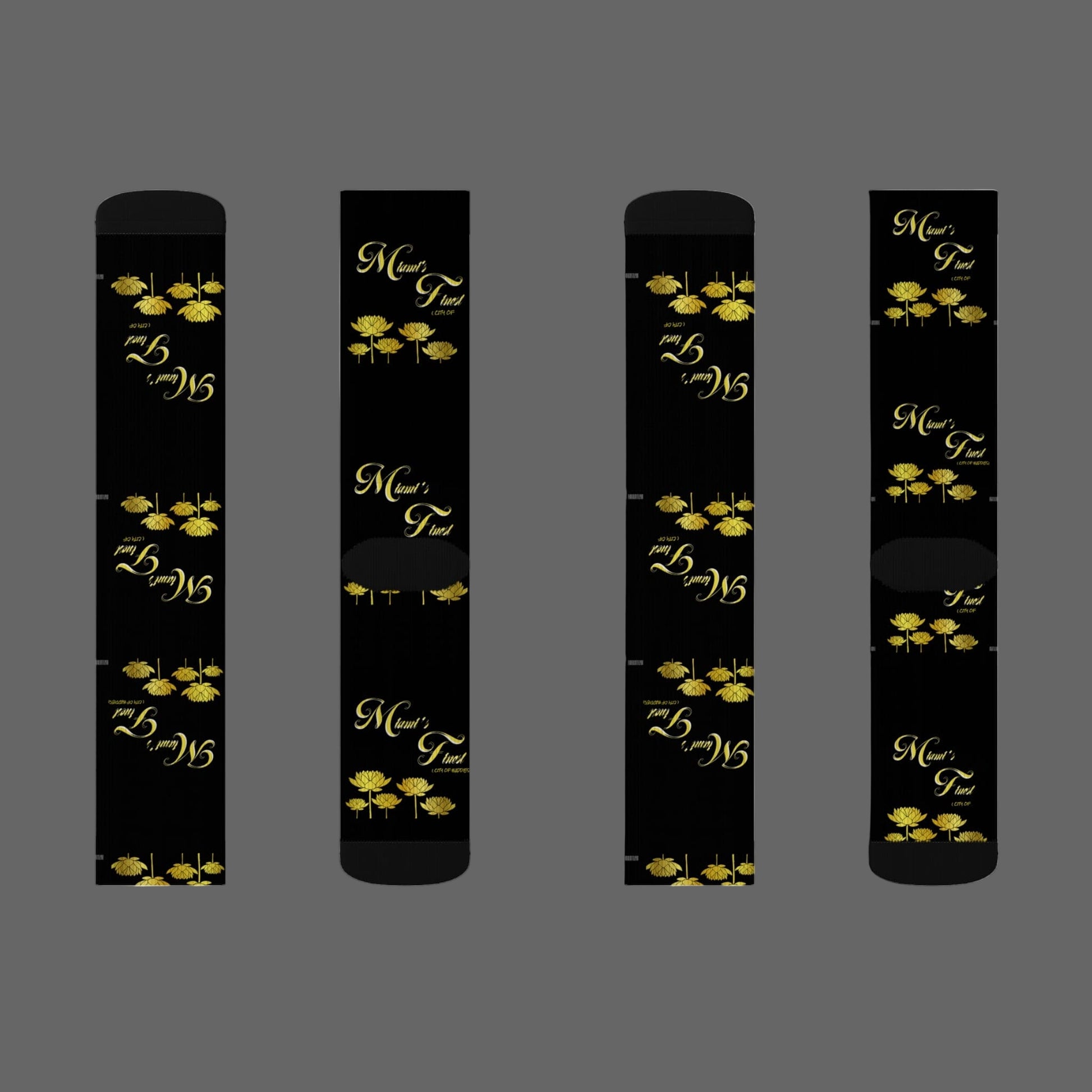 Four black cylindrical products with gold floral designs and text on a white background