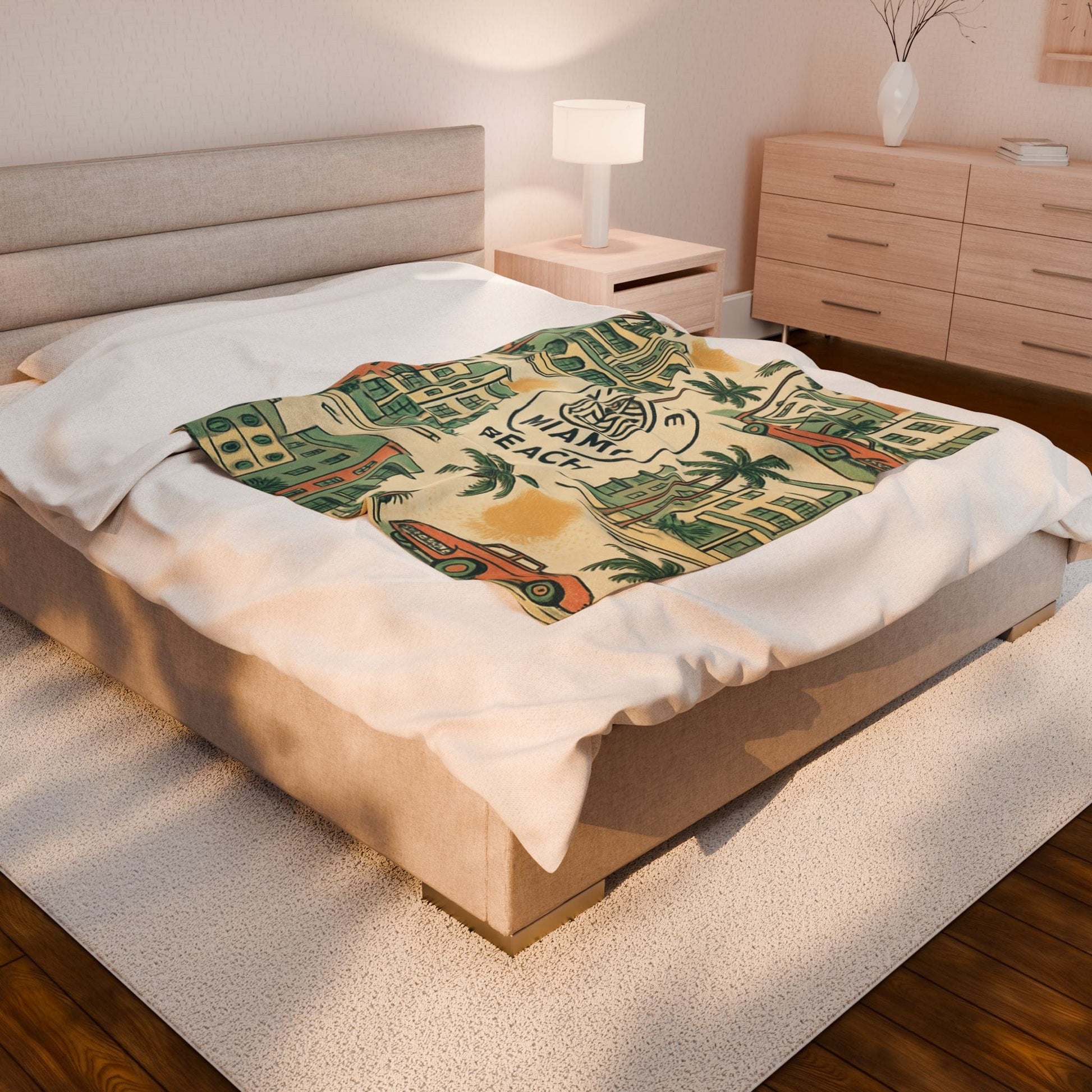Bed with a decorative blanket featuring palm trees and a beach scene in a bedroom setting.