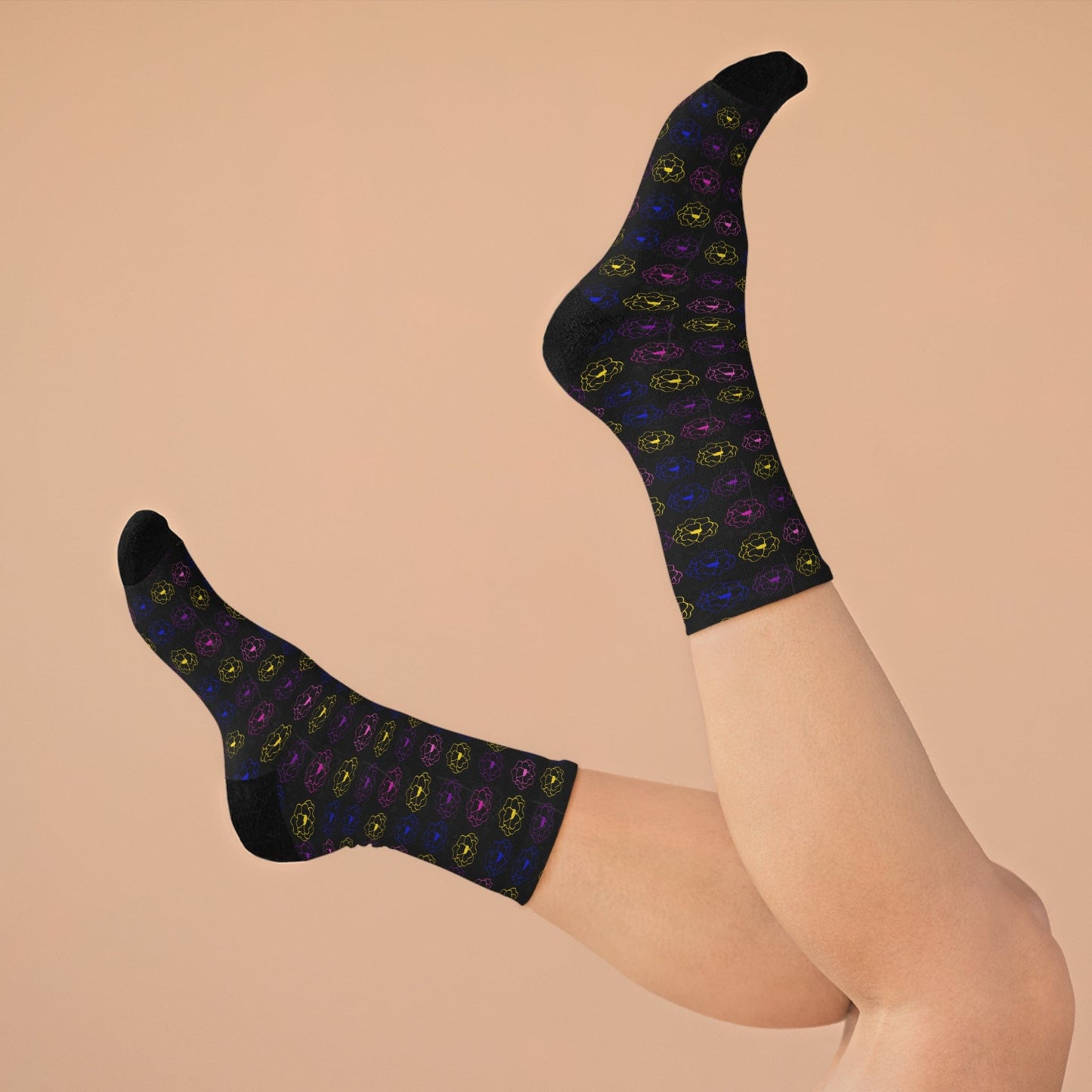 Black socks with colorful patterns worn by a person on a beige background