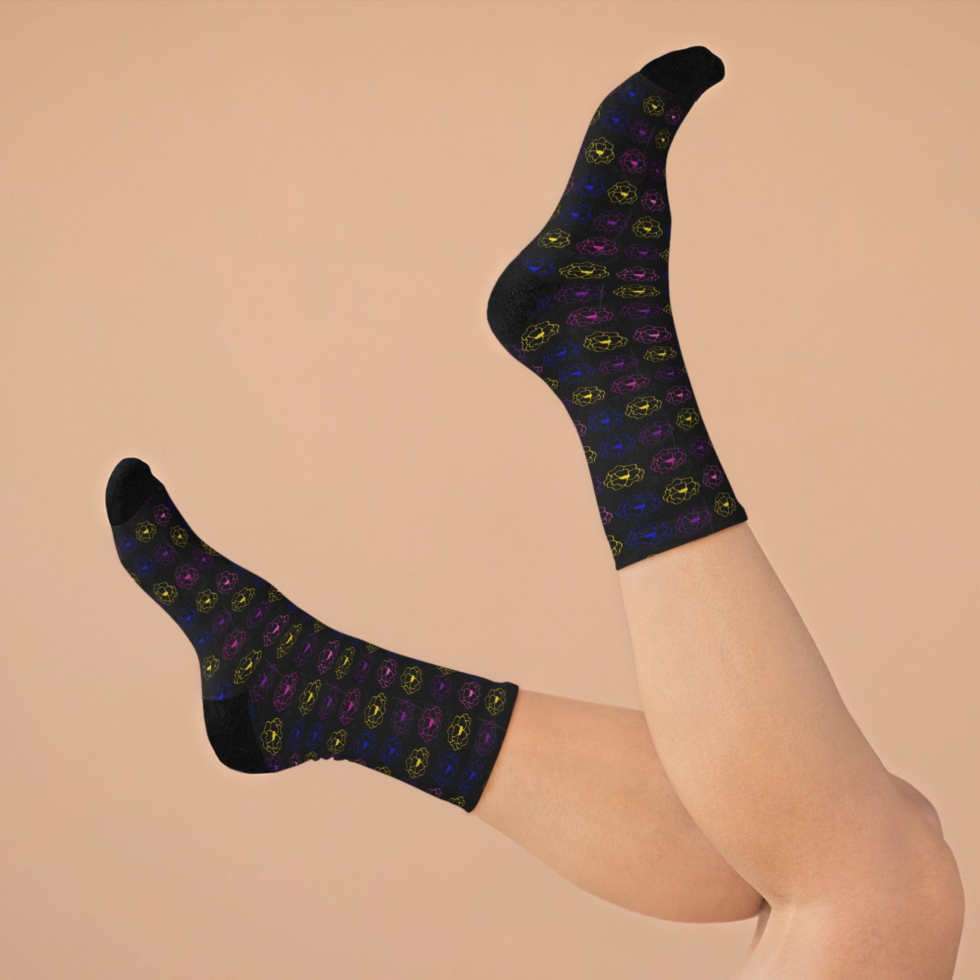 Black socks with colorful patterns worn by a person on a beige background