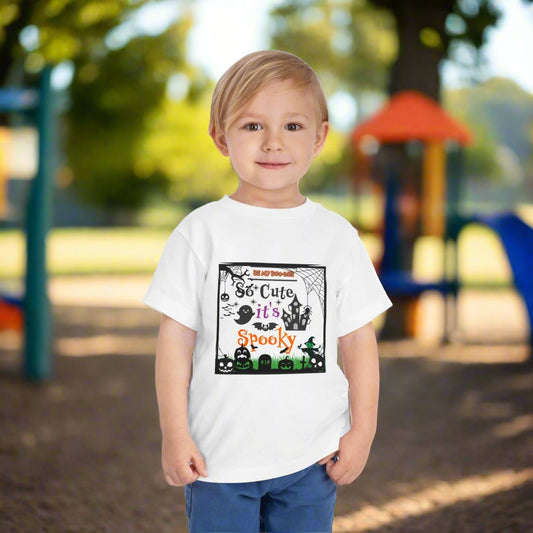 Child wearing a white t-shirt with Halloween-themed design on a white background