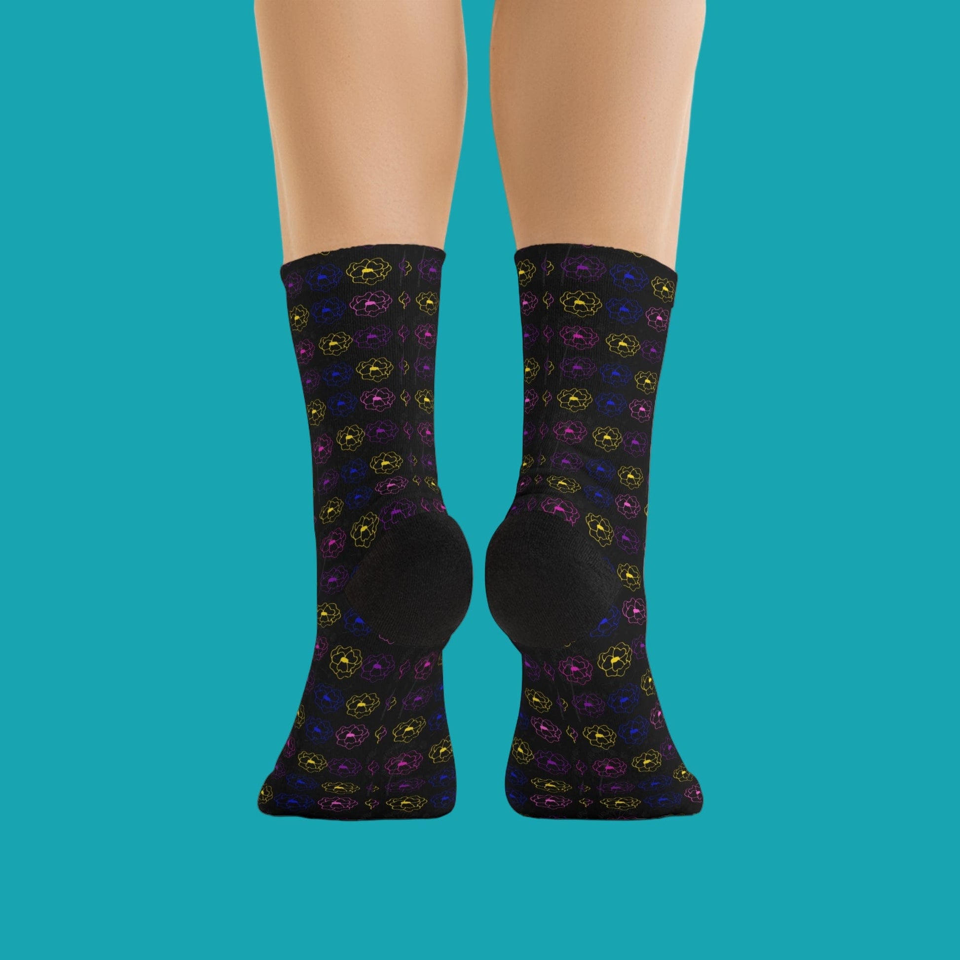 Black socks with colorful pattern worn by a person on a white background
