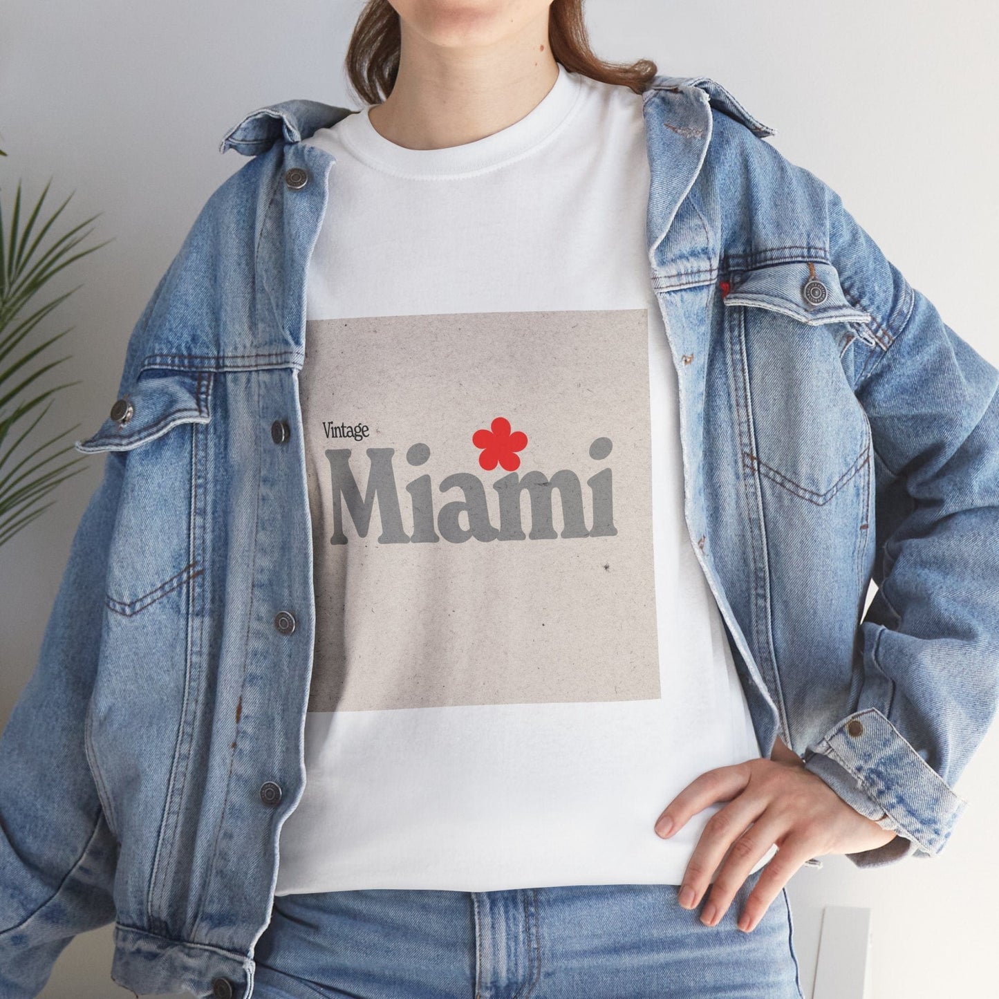 Person wearing a denim jacket over a 'Vintage Miami' t-shirt with a red flower graphic.